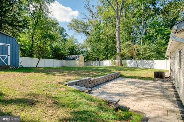 a view of a house with a yard potted plants and large tree