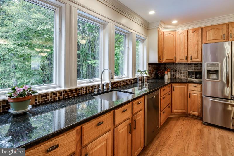 a kitchen with stainless steel appliances a sink window and cabinets