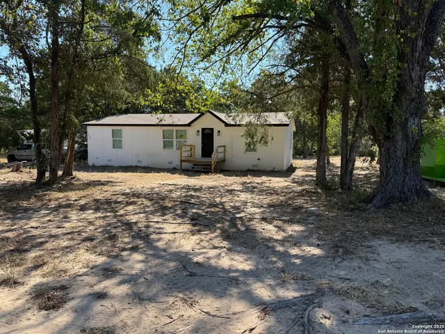 a view of a house with large trees