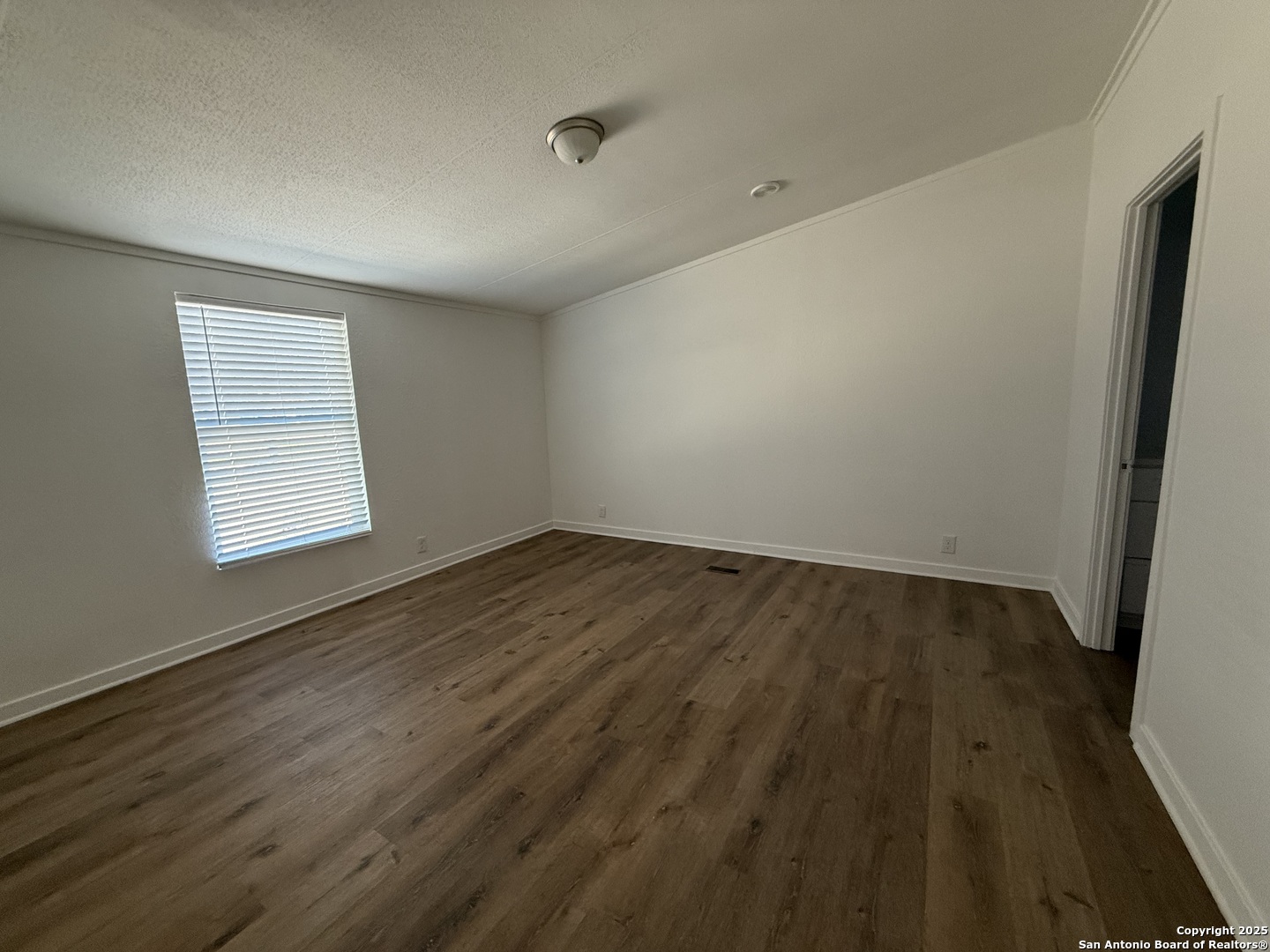 282 Flint Ridge Street Bastrop, TX 78602 - Photo 12 of 12 an empty room with wooden floor and windows