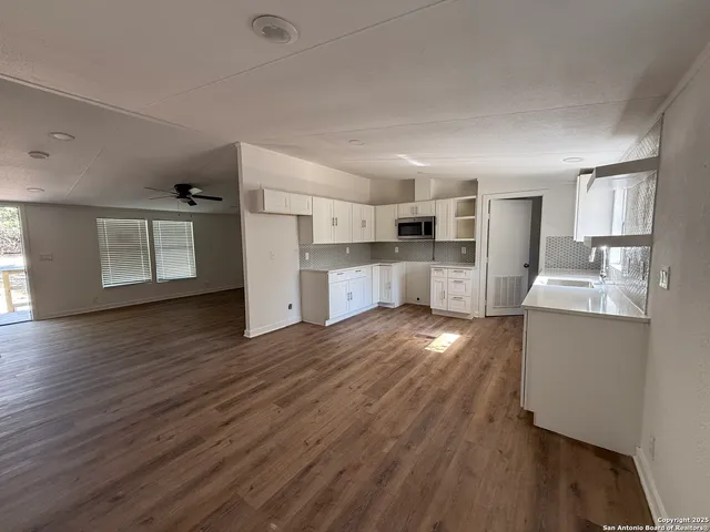 a open kitchen with cabinets and wooden floor