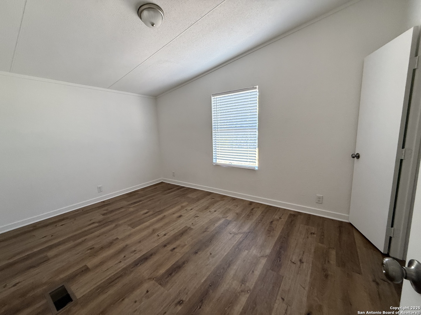 282 Flint Ridge Street Bastrop, TX 78602 - Photo 7 of 12 an empty room with wooden floor and windows