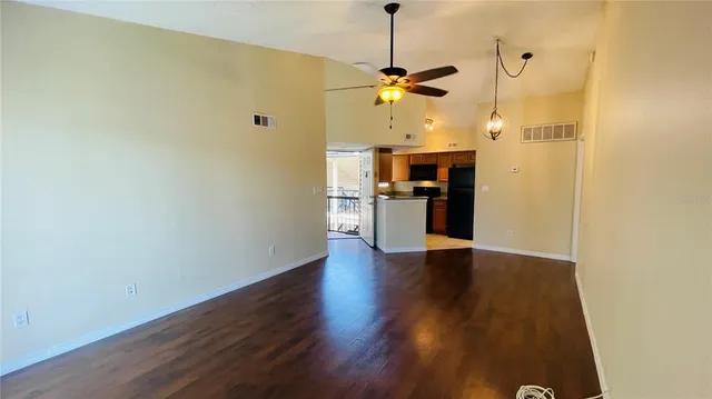 a view of a kitchen with a wooden floor and a ceiling fan