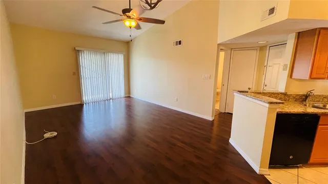 a view of a kitchen with wooden floor and a ceiling fan