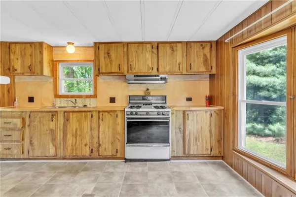 a view of a kitchen with wooden floor and a fireplace