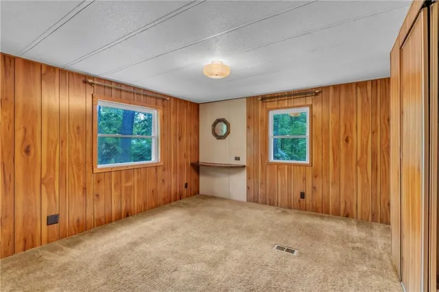 an empty room with windows and closet area