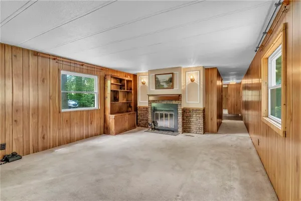 a view of an empty room with a fireplace and a window