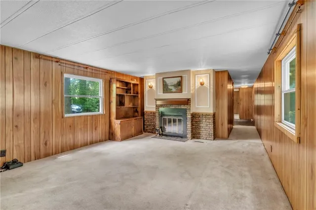 a view of an empty room with a fireplace and a window