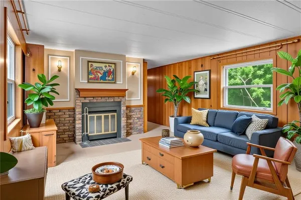 a living room with furniture a large window and a fireplace