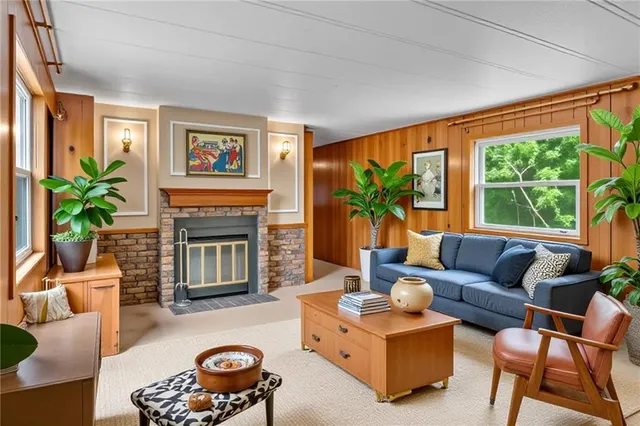 a living room with furniture a large window and a fireplace