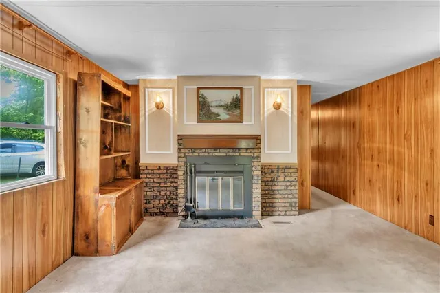 a view of an empty room with fireplace and furniture