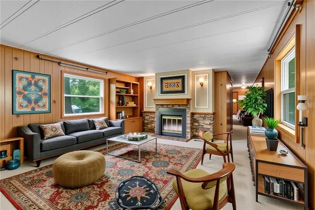 a living room with furniture a fireplace and a large window