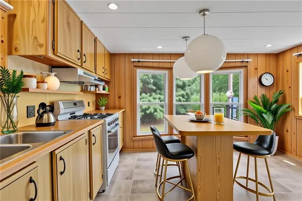a kitchen with stainless steel appliances granite countertop a sink a stove and a refrigerator