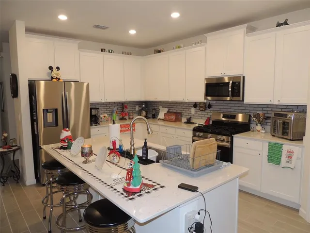 a kitchen with a sink a stove and chairs