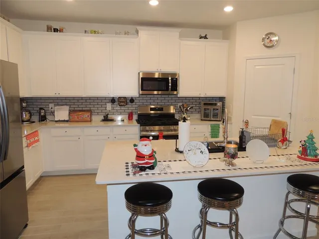 a kitchen with a dining table chairs and a refrigerator