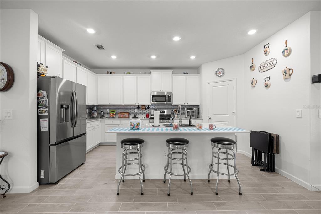 560 Northwest 4th Avenue Williston, FL 32696 - Photo 14 of 31 a kitchen with stainless steel appliances granite countertop a dining table chairs refrigerator and cabinets
