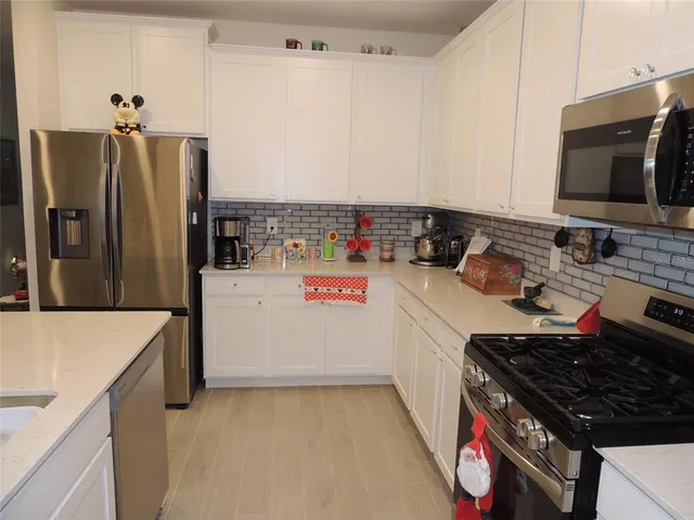 a kitchen with a refrigerator and a stove top oven