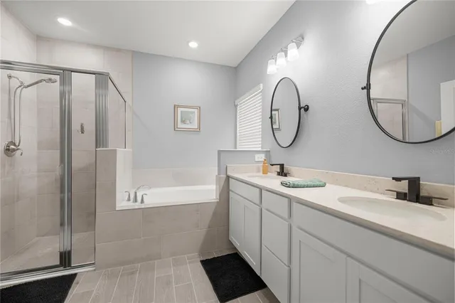 a bathroom with a double vanity sink mirror and shower