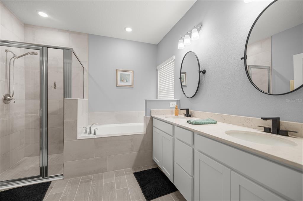 560 Northwest 4th Avenue Williston, FL 32696 - Photo 20 of 31 a bathroom with a double vanity sink mirror and shower