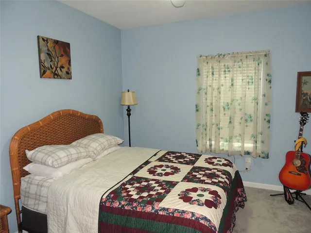 a bedroom with a bed a wall painting and a window