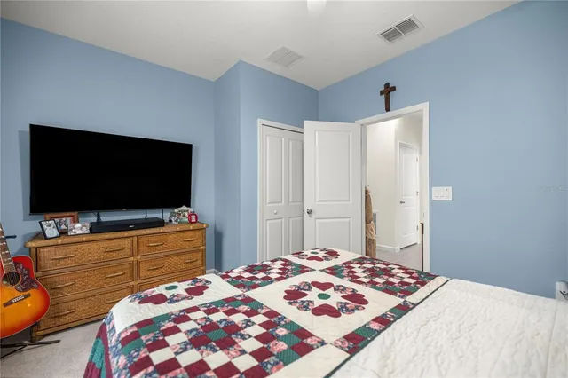 a bedroom with a bed and a flat screen tv in it