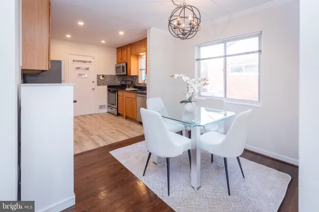 a kitchen with a dining table chairs and refrigerator