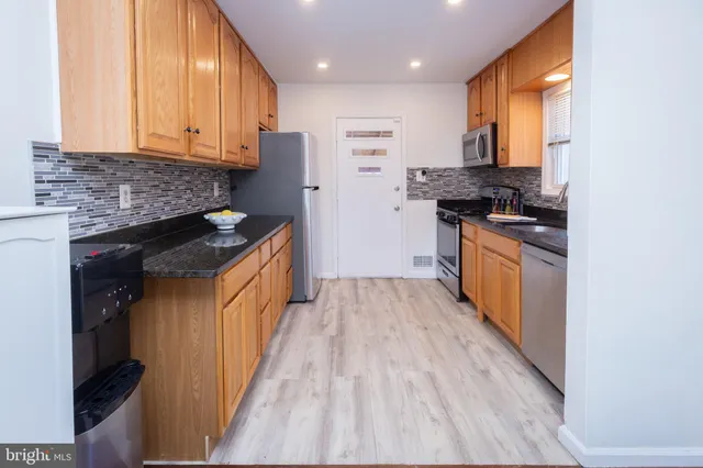 a kitchen with stainless steel appliances granite countertop a stove a sink and a refrigerator