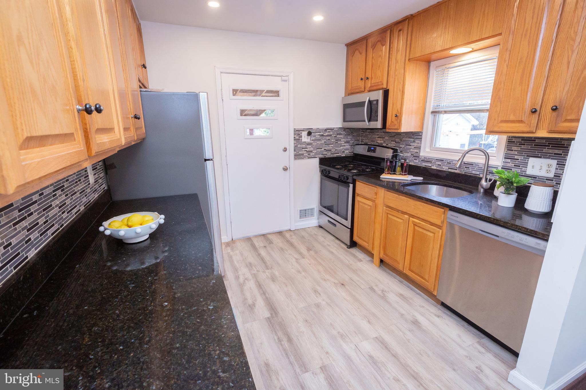 3945 Wendy Lane Silver Spring, MD 20906 - Photo 8 of 45 a kitchen with stainless steel appliances a stove a sink and a refrigerator