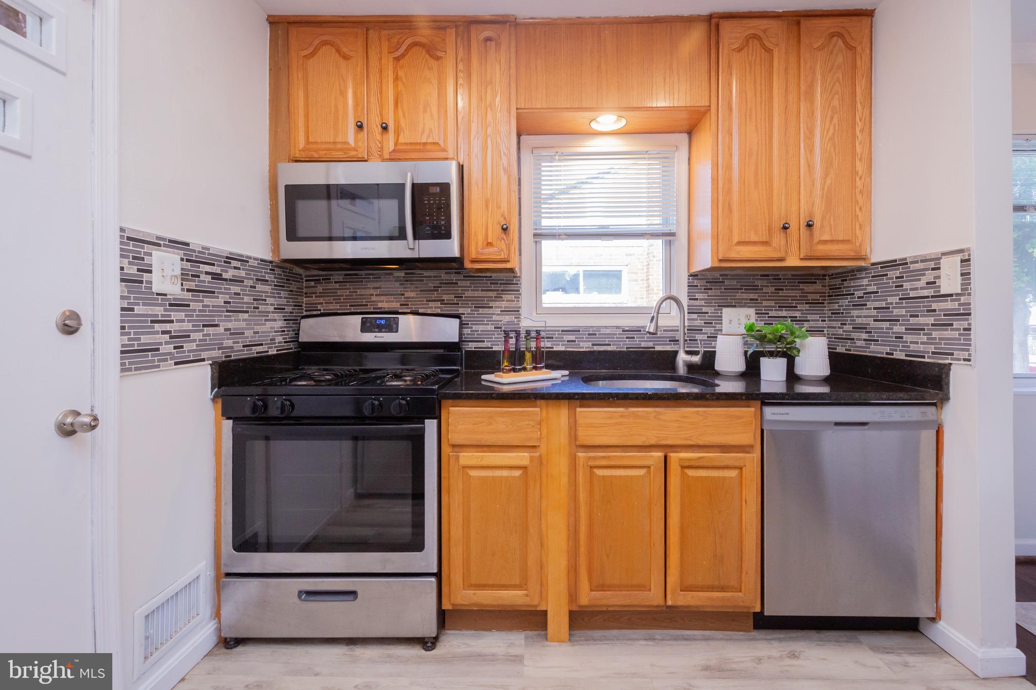 3945 Wendy Lane Silver Spring, MD 20906 - Photo 9 of 45 a kitchen with stainless steel appliances granite countertop a stove a sink and a microwave