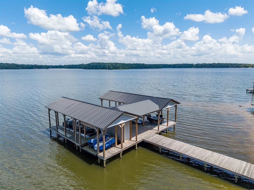 16241 Big Oak Bay Road Tyler, TX 75707 - Photo 35 of 40 Private dock with two covered boat slips featuring metal roofs and a long wood-finish walkway
