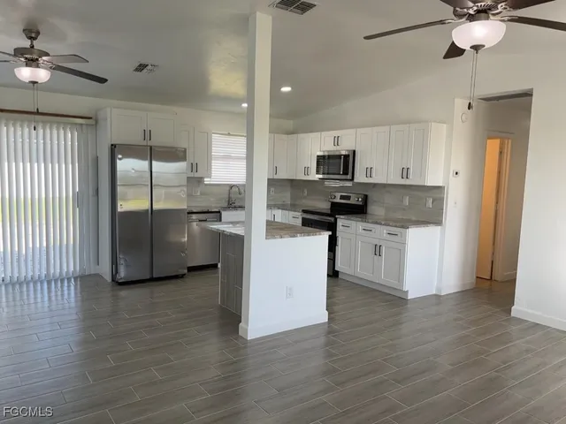 a kitchen with stainless steel appliances a refrigerator sink and microwave