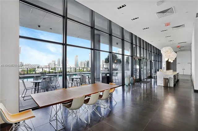 a view of a living room with furniture and floor to ceiling window