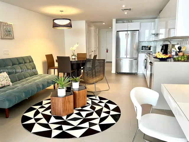 a living room with furniture and kitchen view