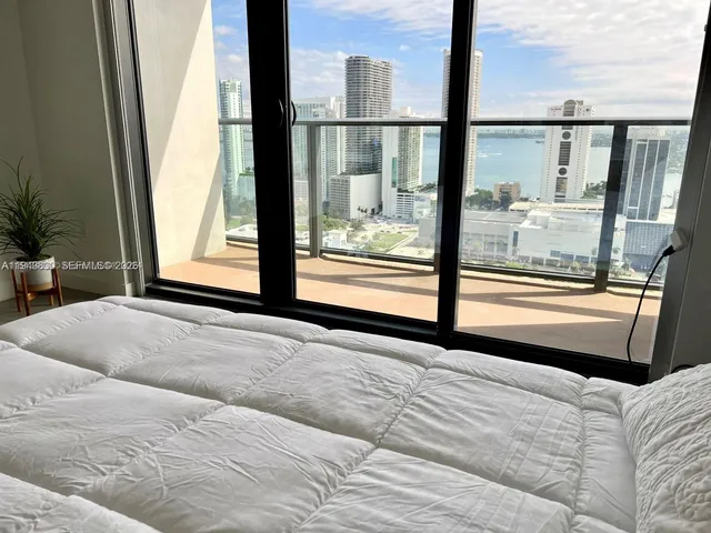 a bedroom with a large window and a balcony