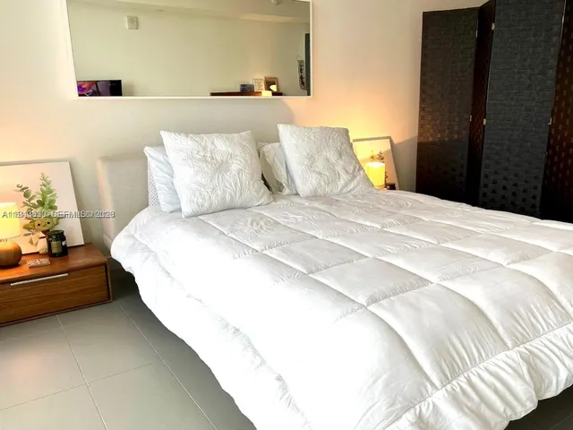 a bedroom with a bed and a night stand