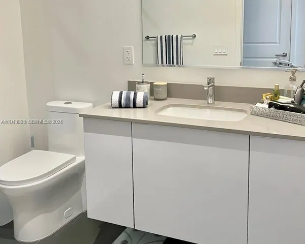 a bathroom with a sink toilet and mirror