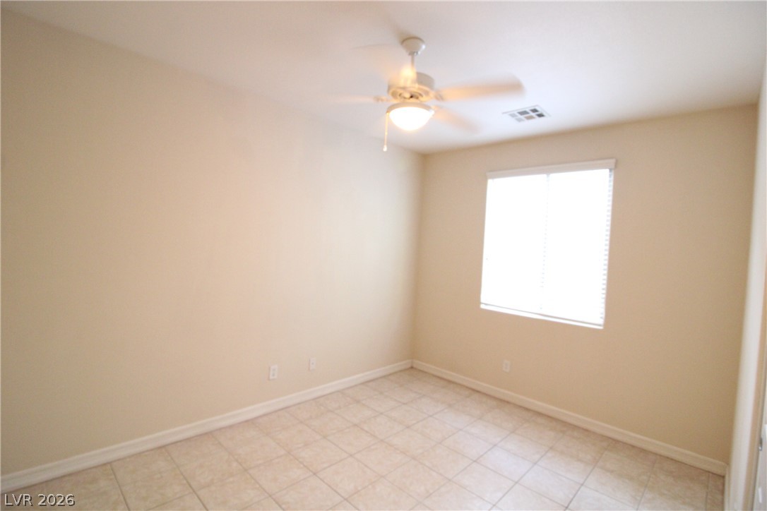 754 Rise Canyon Drive Henderson, NV 89052 - Photo 12 of 34 A well-lit room featuring durable tile flooring and a ceiling fan for comfort.