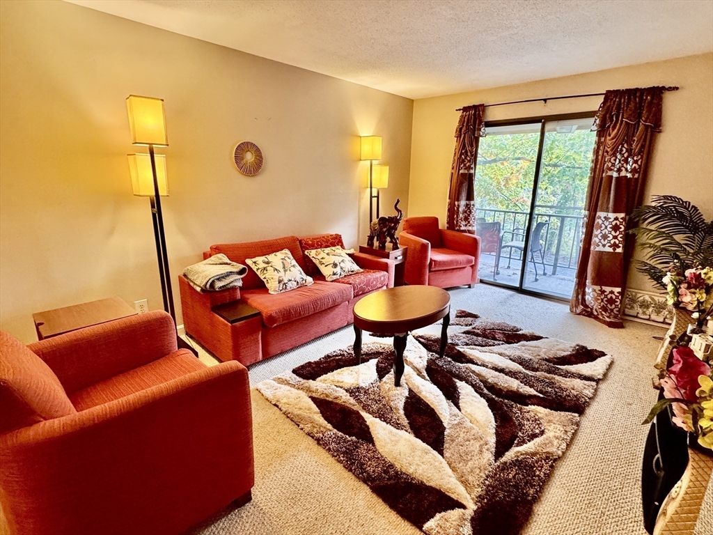3 Greenbriar Drive, Unit 303 North Reading, MA 01864 - Photo 1 of 16 a living room with furniture and a floor to ceiling window