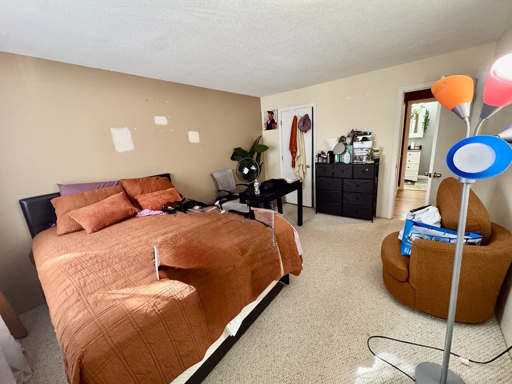 3 Greenbriar Drive, Unit 303 North Reading, MA 01864 - Photo 11 of 16 a bedroom with bed and wooden floor