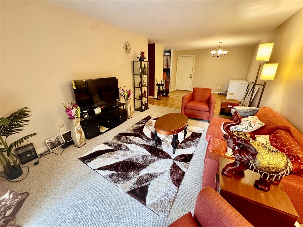 3 Greenbriar Drive, Unit 303 North Reading, MA 01864 - Photo 3 of 16 a living room with furniture and a flat screen tv