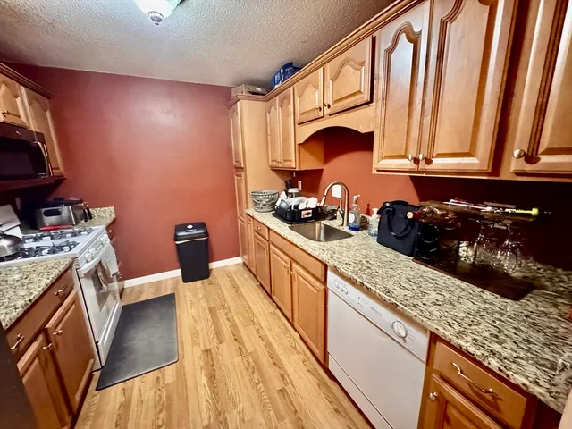 a kitchen with stainless steel appliances granite countertop a stove a sink and a microwave
