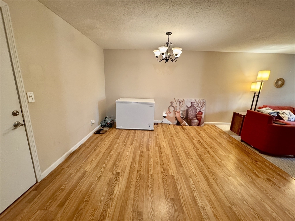 3 Greenbriar Drive, Unit 303 North Reading, MA 01864 - Photo 6 of 16 a bed room with a bed mirror and wooden floor