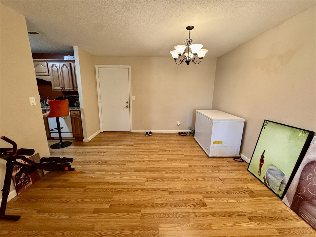 3 Greenbriar Drive, Unit 303 North Reading, MA 01864 - Photo 7 of 16 a bedroom with a bed and a chandelier