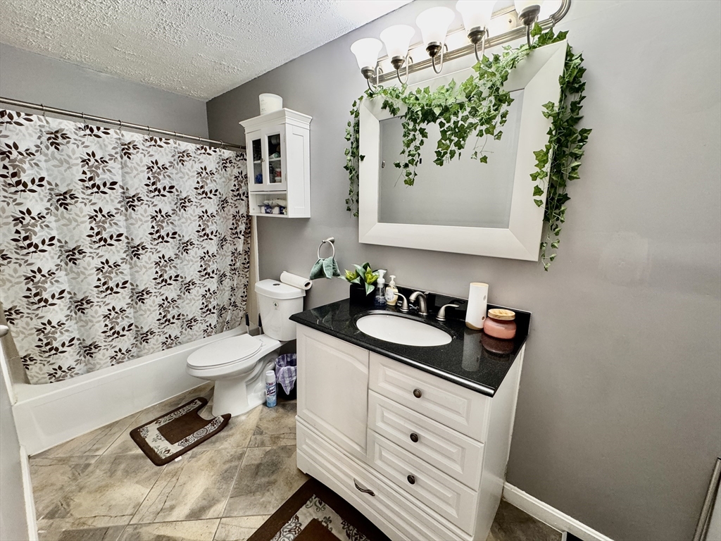 3 Greenbriar Drive, Unit 303 North Reading, MA 01864 - Photo 10 of 16 a bathroom with a granite countertop sink and a toilet