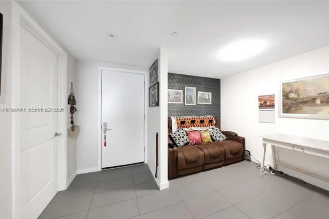 a living room with furniture and a baby crib