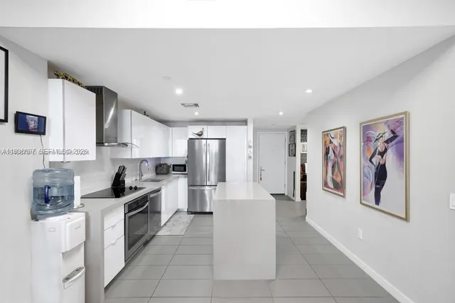 a kitchen with stainless steel appliances granite countertop a refrigerator and a stove top oven