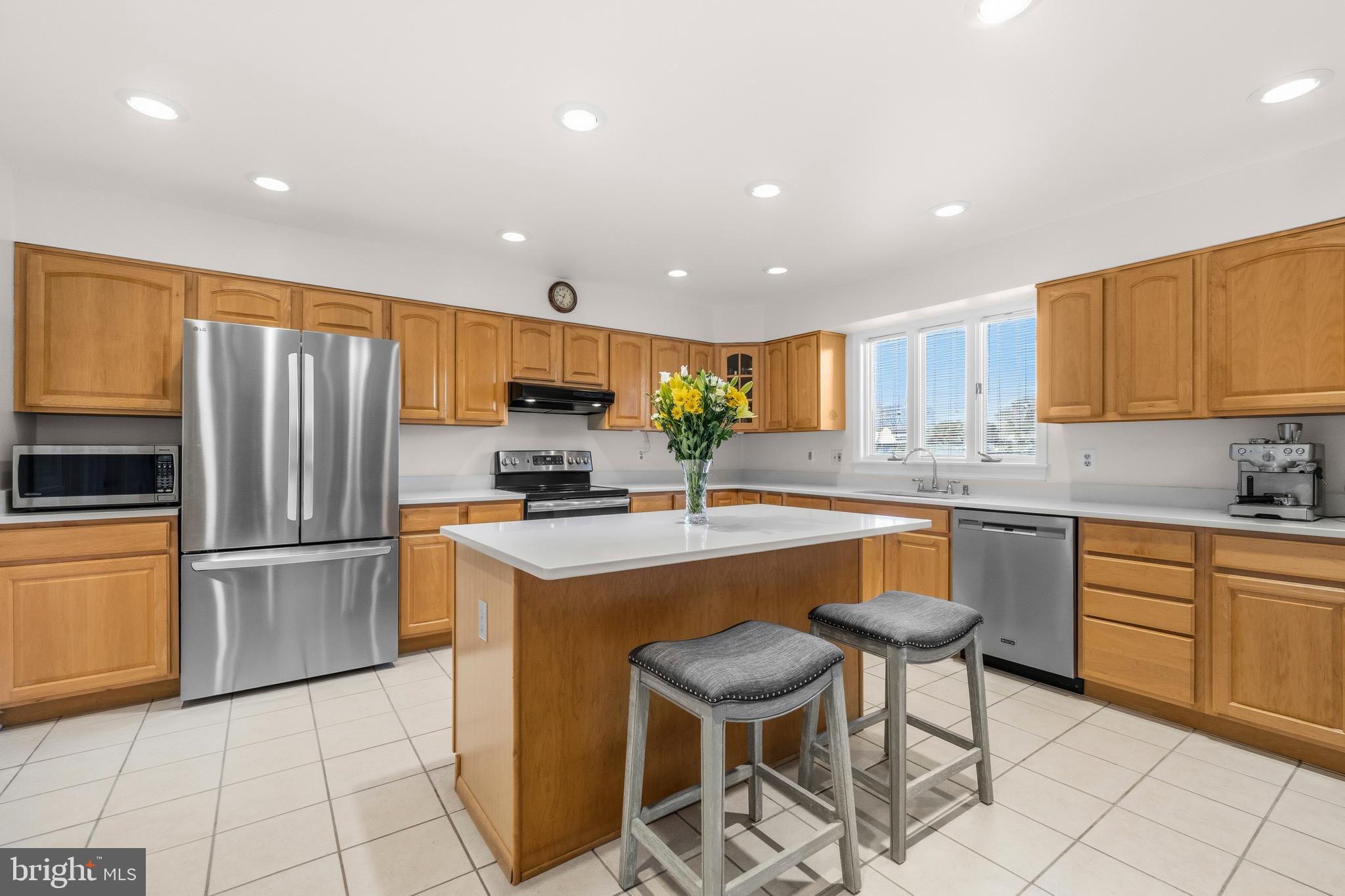 16170 Ed Warfield Road Woodbine, MD 21797 - Photo 27 of 80 a kitchen with granite countertop a stove a sink dishwasher a refrigerator and cabinets with wooden floor