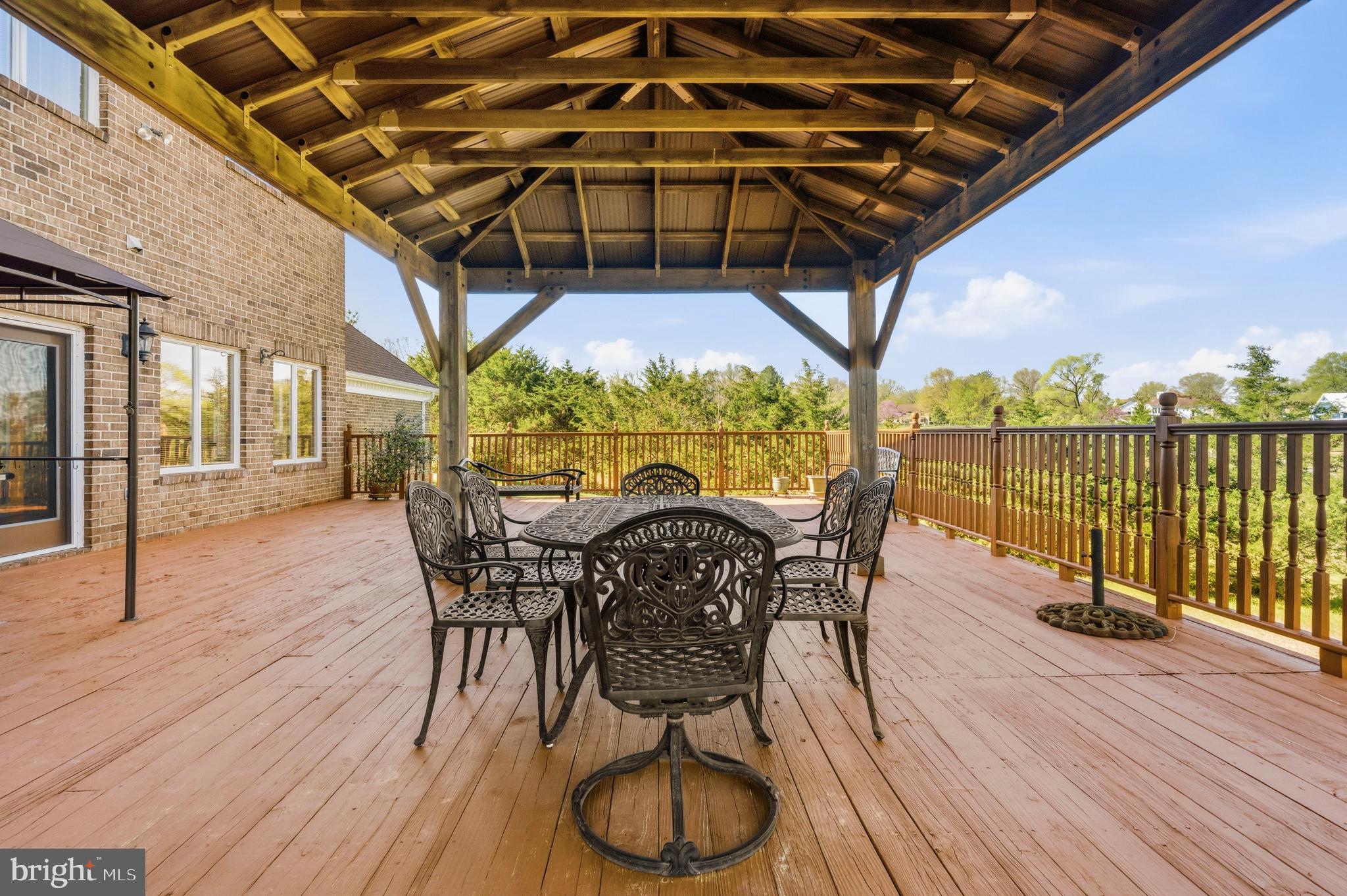 16170 Ed Warfield Road Woodbine, MD 21797 - Photo 34 of 80 a patio with wooden floor a yard a table and chairs