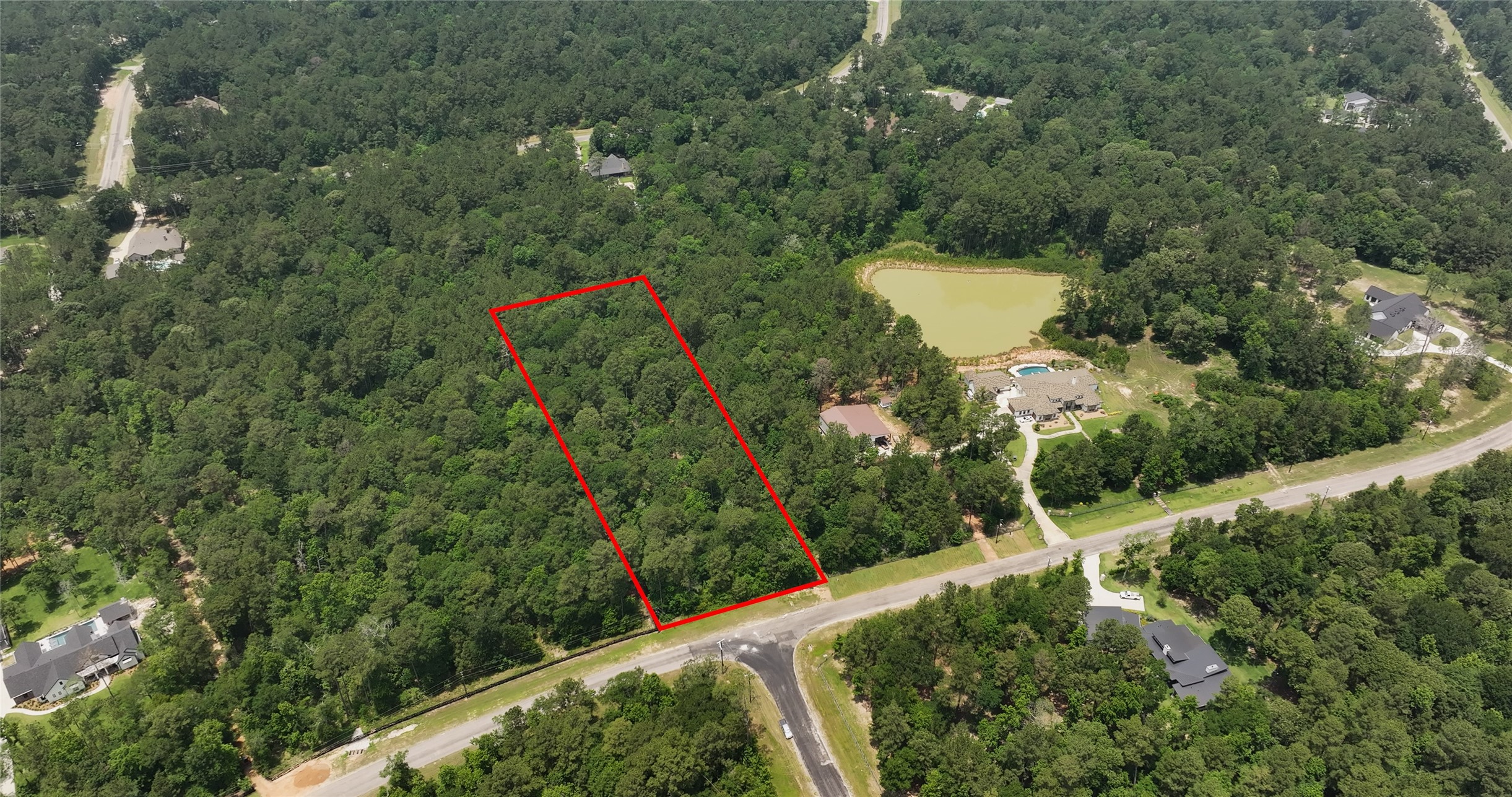 an aerial view of a house with a yard and lake