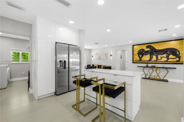 a kitchen with stainless steel appliances kitchen island granite countertop a refrigerator and a stove top oven